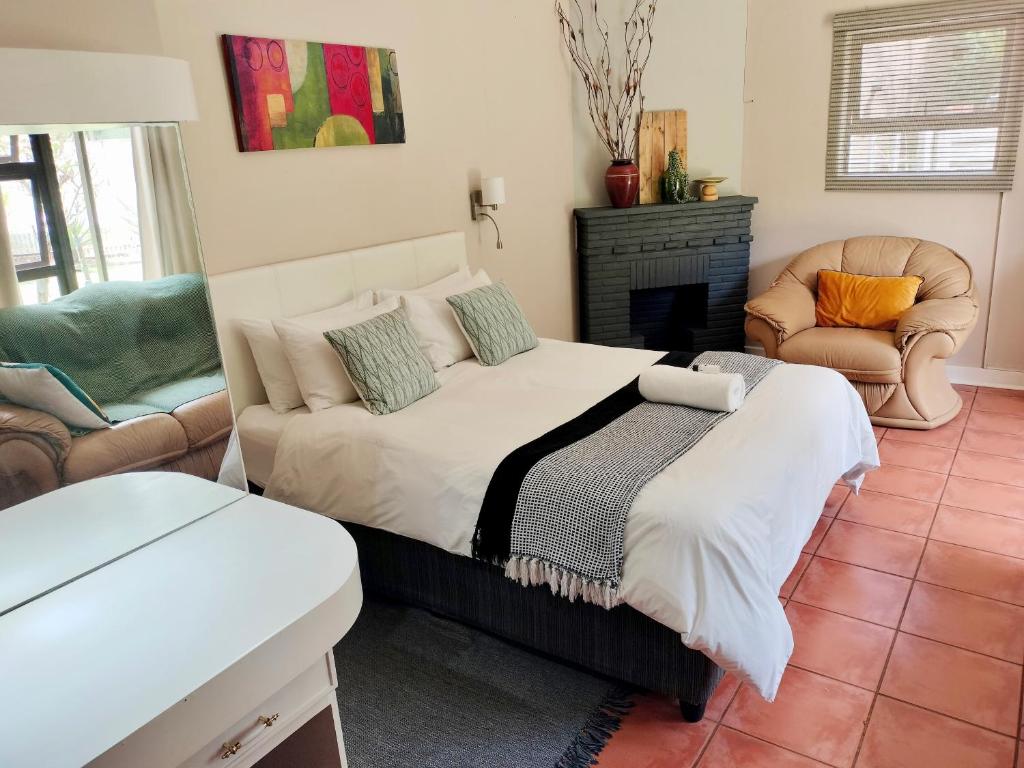 a bedroom with a bed and a couch and a fireplace at Easy Inn Guesthouse in Welkom