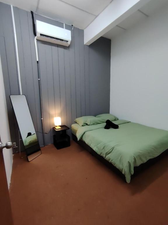 a bedroom with a bed with a cat sitting on it at Ayla Hostel at MITC in Ayer Keroh