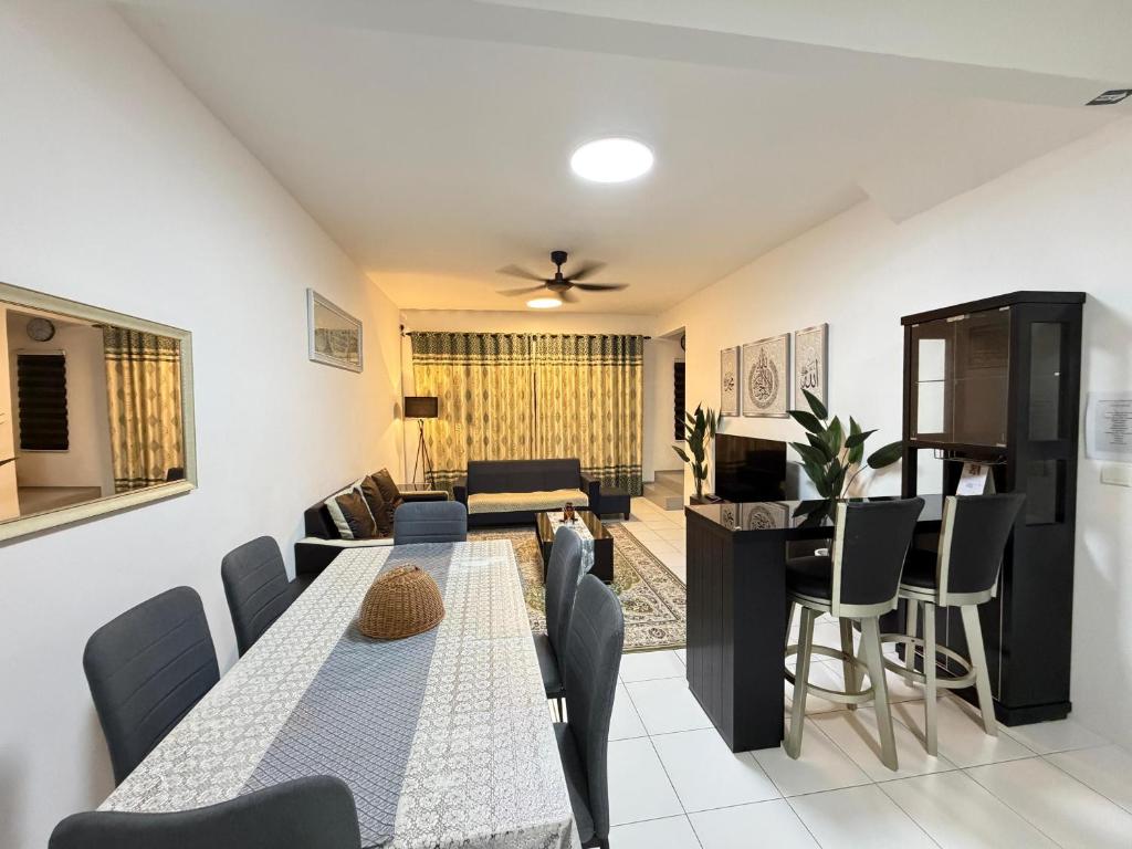 a dining room and living room with a table and chairs at QA Homestay in Tawau