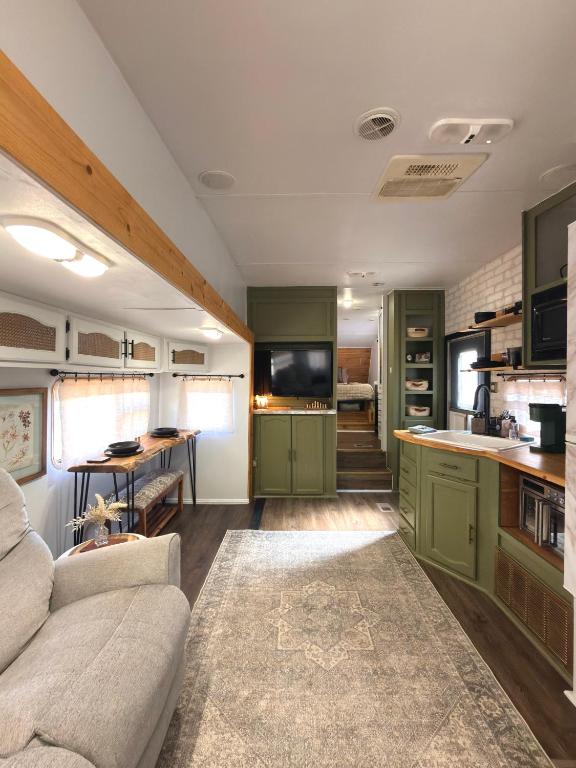 a living room with a couch and a kitchen at The Pendle-Tin in Pendleton