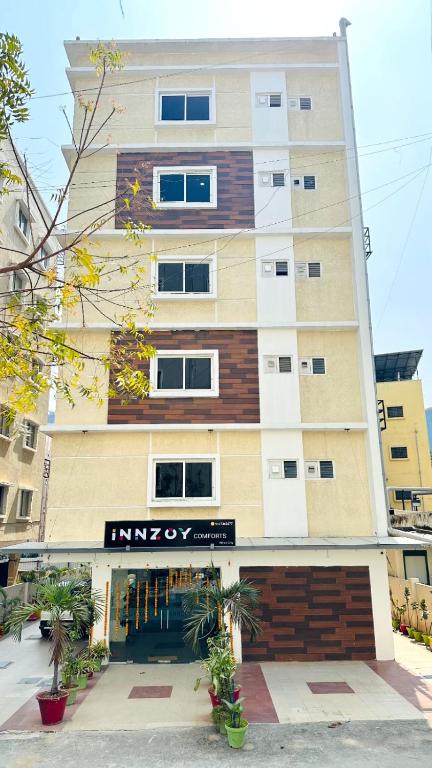 a tall building with a sign in front of it at Innzoy Comforts - Hitech City Hyderabad in Hyderabad