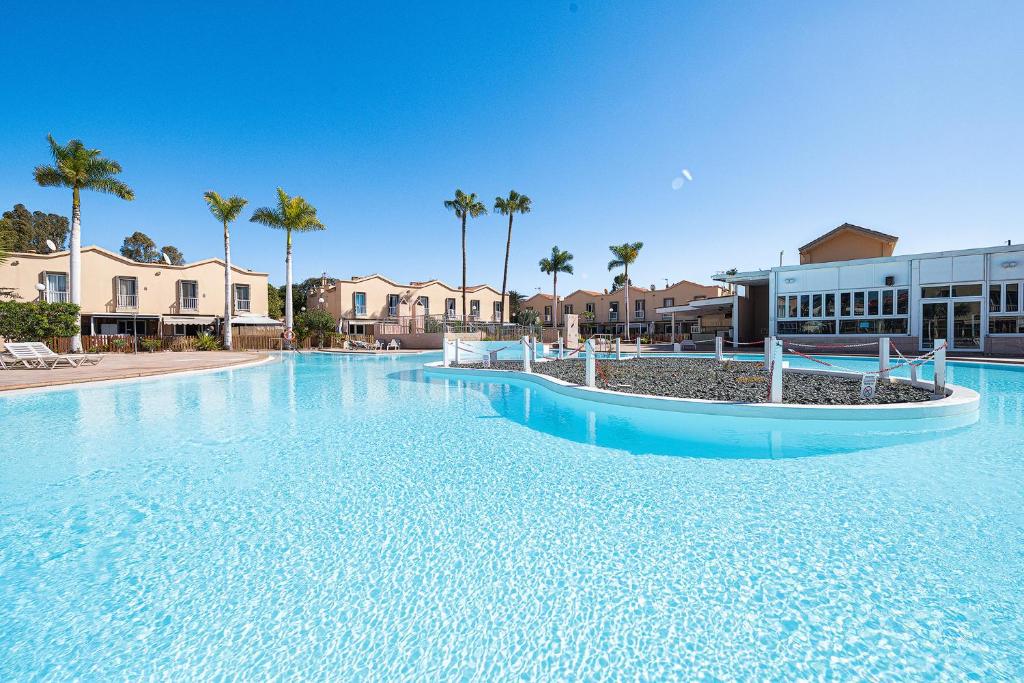 a large swimming pool in a resort with palm trees at Maspalomas Green Oasis 1404 in Maspalomas