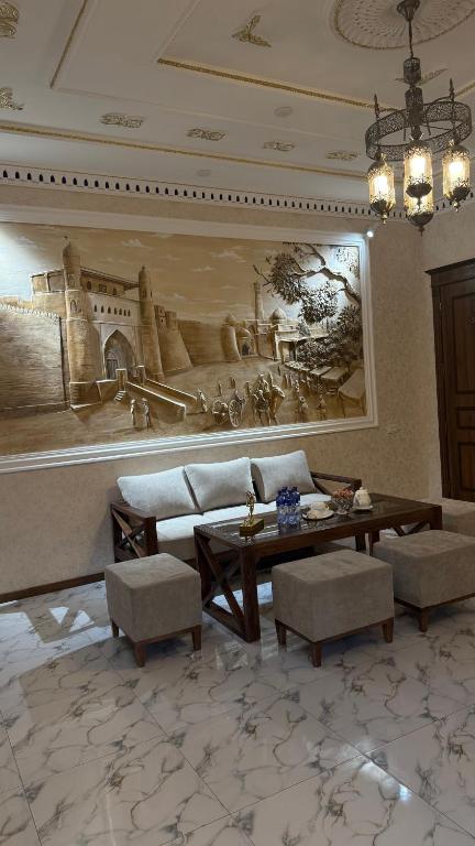 a living room with a painting on the wall at Al Fayz Boutique in Bukhara