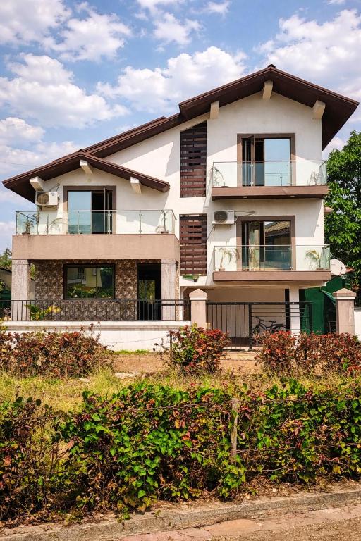 a large white house with windows on a hill at Hangout Villa in Malavli