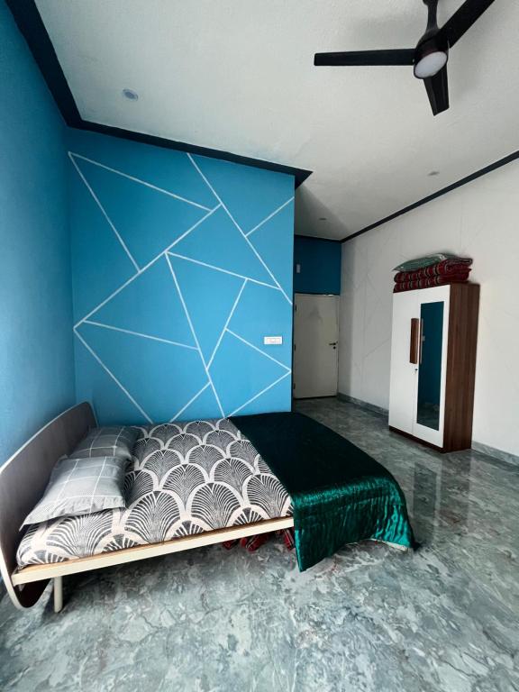 a room with a bed with a blue wall at Chamundi Temple-Hill View in Mysore