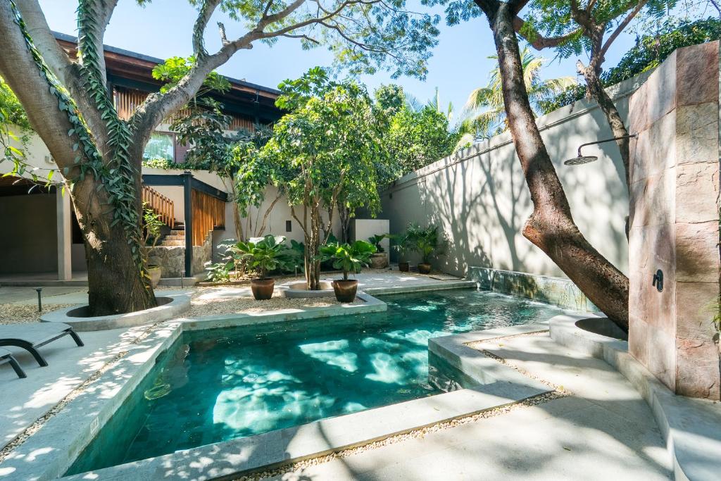 a swimming pool in a yard with trees at Welcome to Paradise - Luxurious Studio Oasis "Artemisa" with Pool and Lush Tropical Gardens in Sayulita