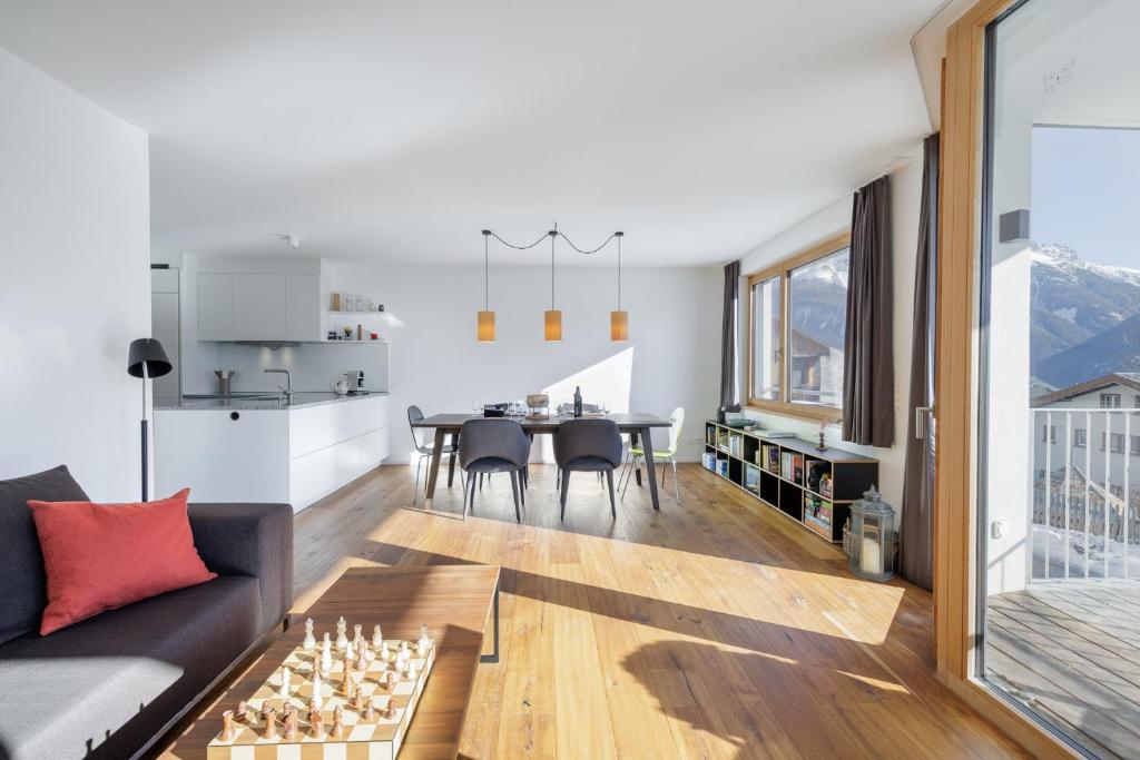a living room with a couch and a chess board on a table at Chasa AlpVista in Sent