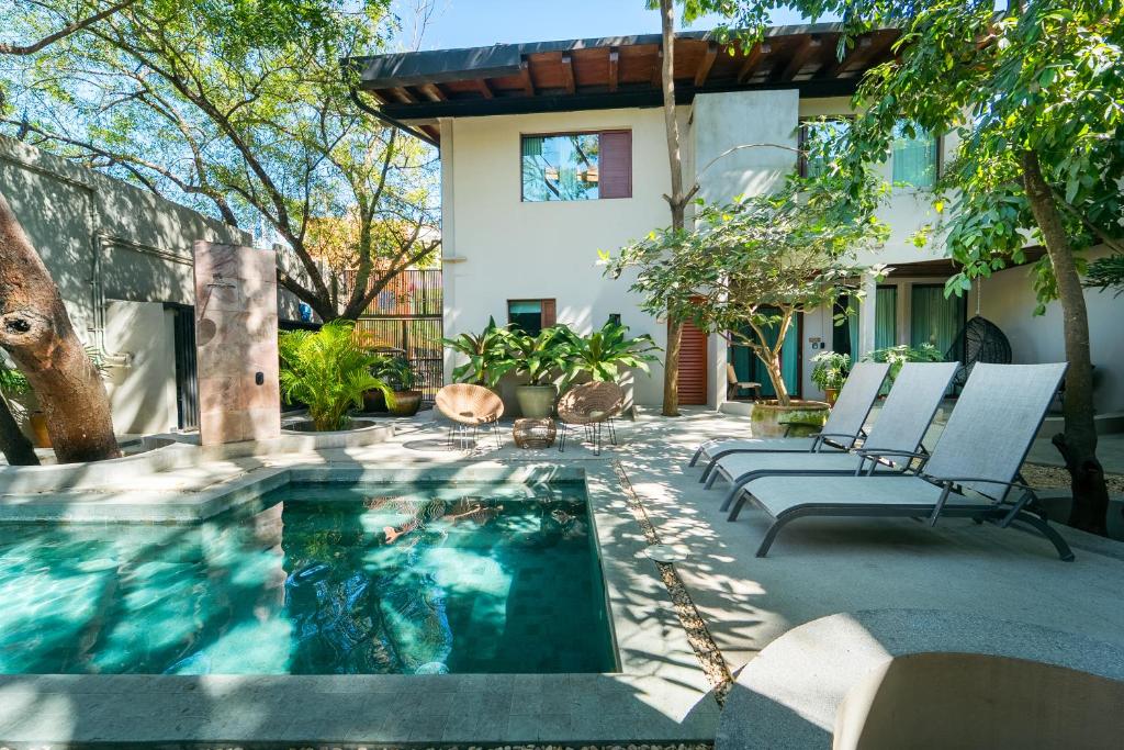 a swimming pool with two chairs and a house at Welcome to Paradise - Luxurious Studio Oasis "Urania" with Pool and Lush Tropical Gardens in Sayulita