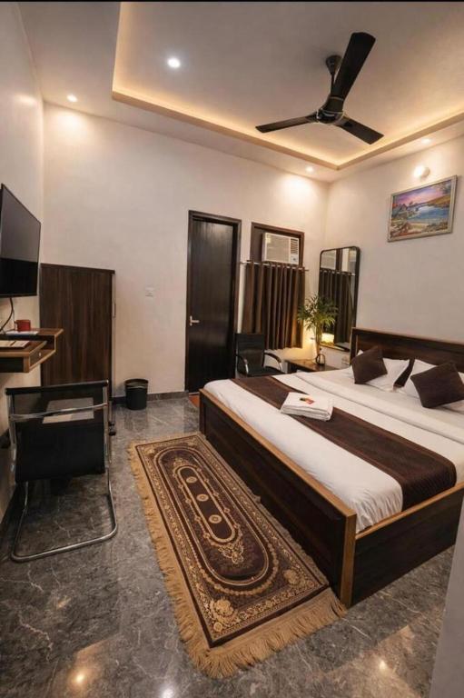 a bedroom with a large bed and a desk at Hotel Nidhivan Dham - Near Janam Bhoomi Mathura in Mathura