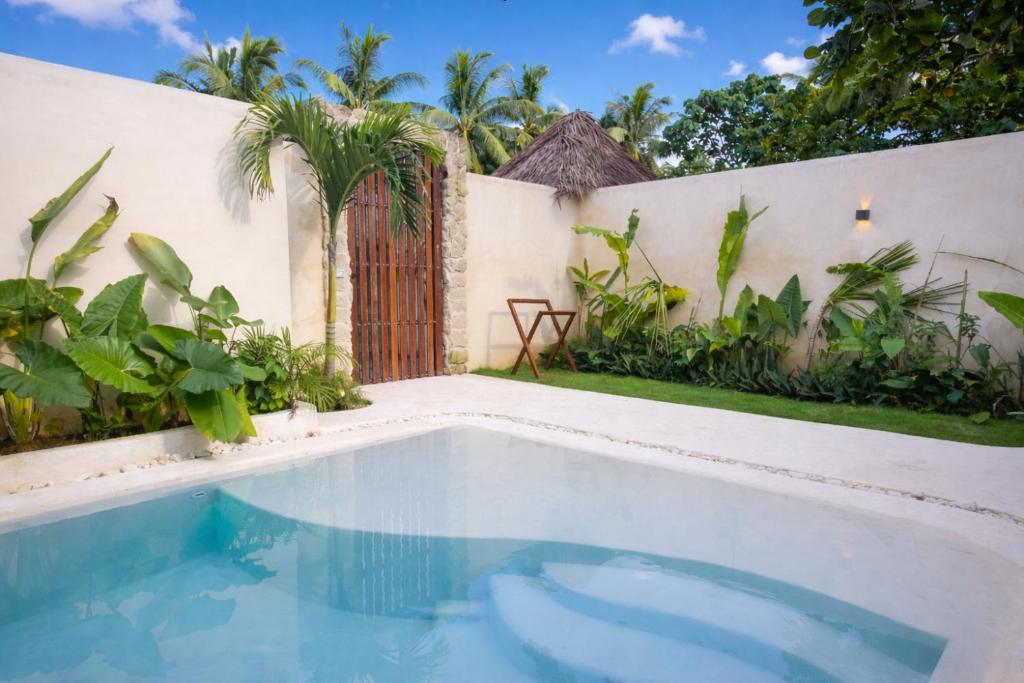 a swimming pool in front of a house with a gate at Nala Villas in General Luna
