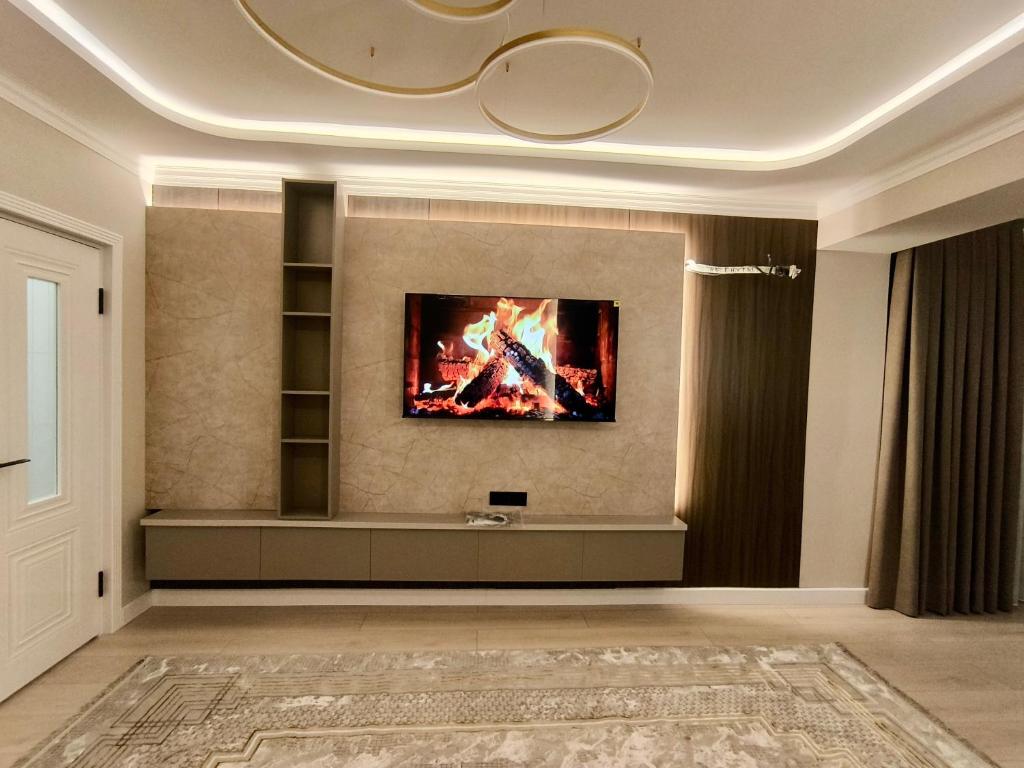 a living room with a fire on the wall at Life park Osh 2 in Osh