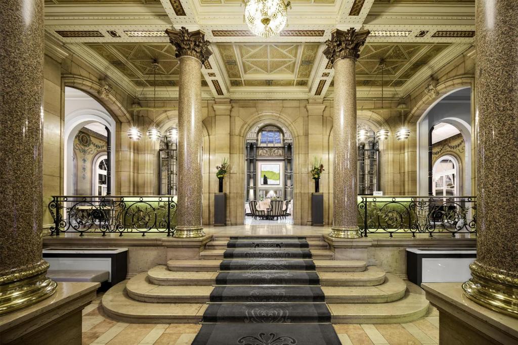 a lobby with columns and a staircase in a building at Hilton Paris Opera in Paris