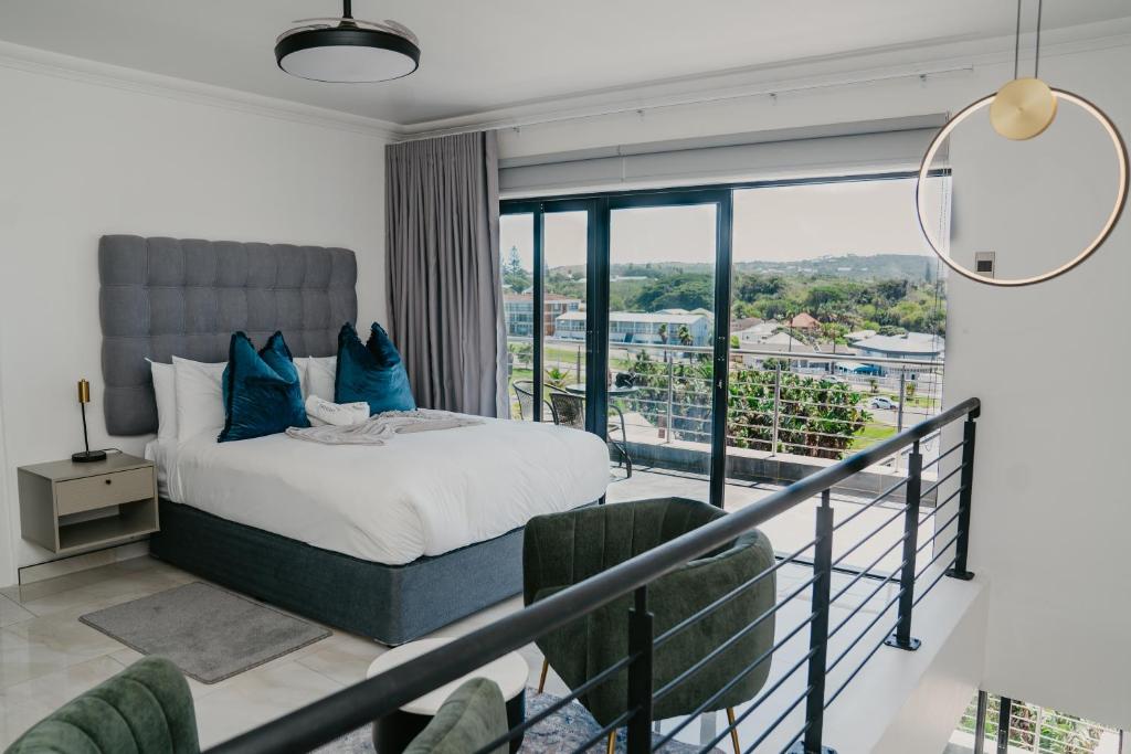 a bedroom with a bed and a balcony at Gonubie Beachside Delight Apartment in East London