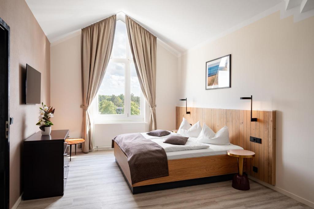 a bedroom with a large bed and a window at Atrium Hotel Krüger in Rostock