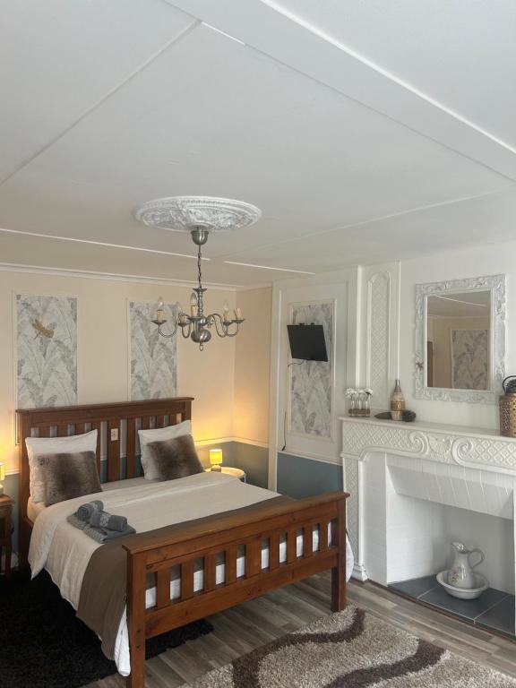 a bedroom with a large bed and a fireplace at The LightHouse Chambres à louer in Châteaulin