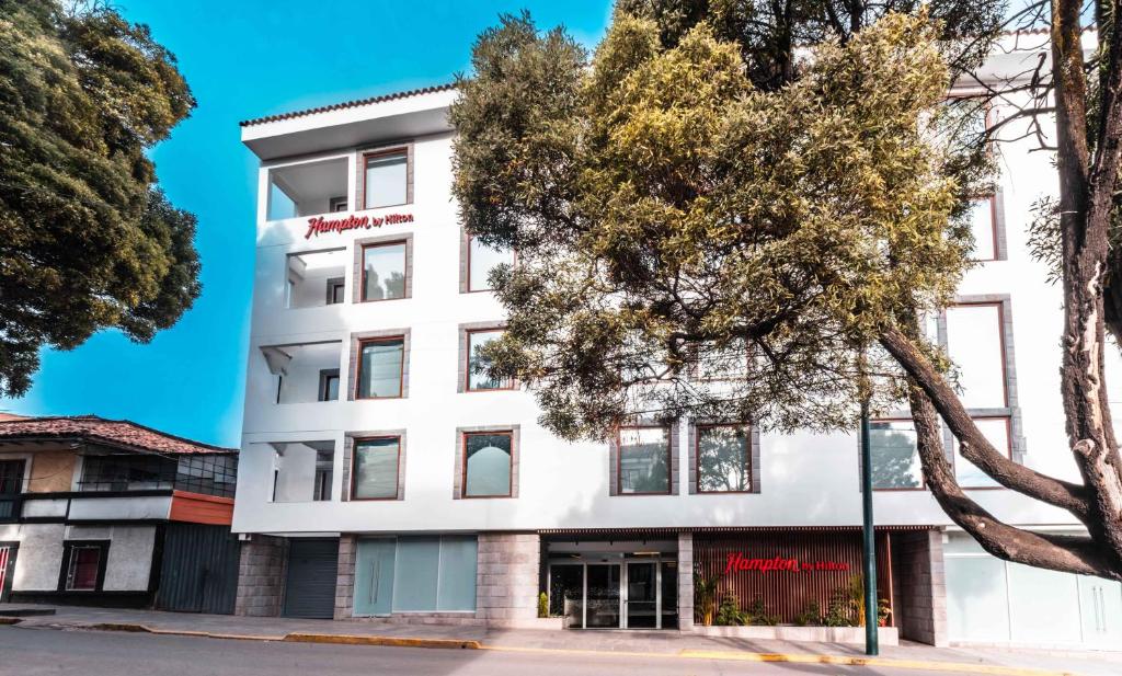 a white building with trees in front of it at Hampton By Hilton Cusco in Cusco