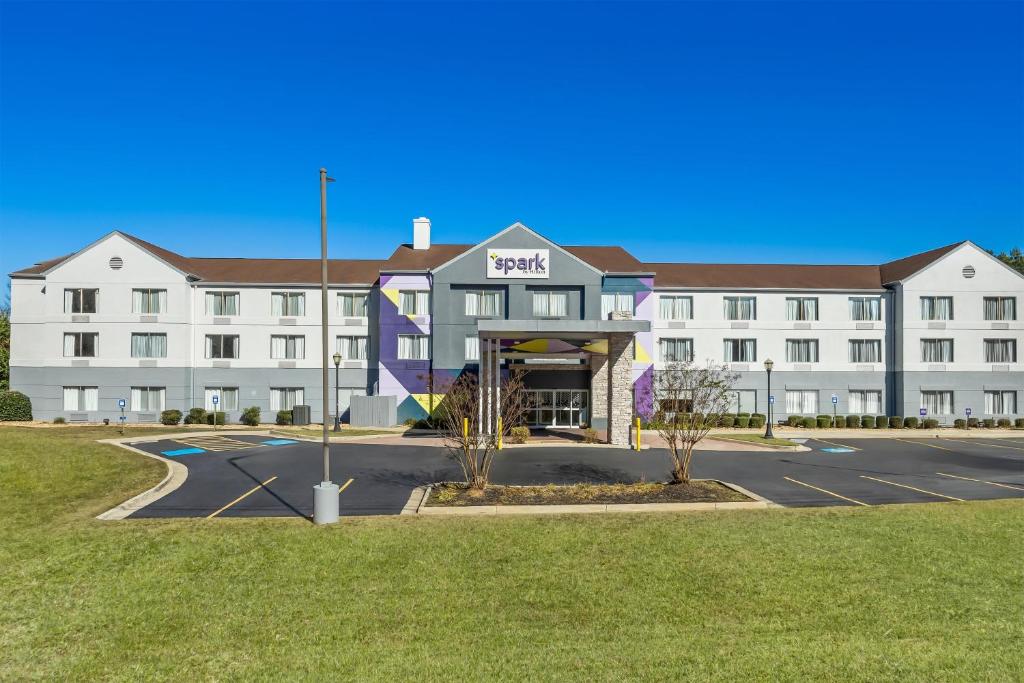 a large white building with a parking lot at Spark by Hilton Macon North in Macon