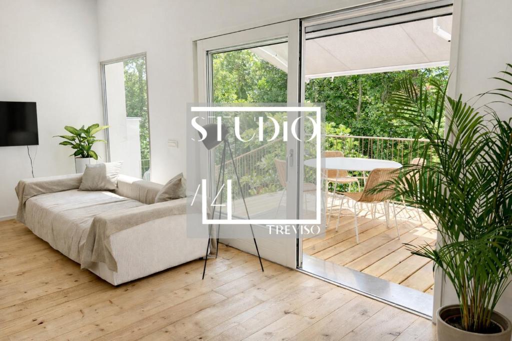 a living room with a couch and a table at STUDIO 14 - apt design con terrazza sul fiume - 2 biciclette incluse - vicino al centro in Treviso
