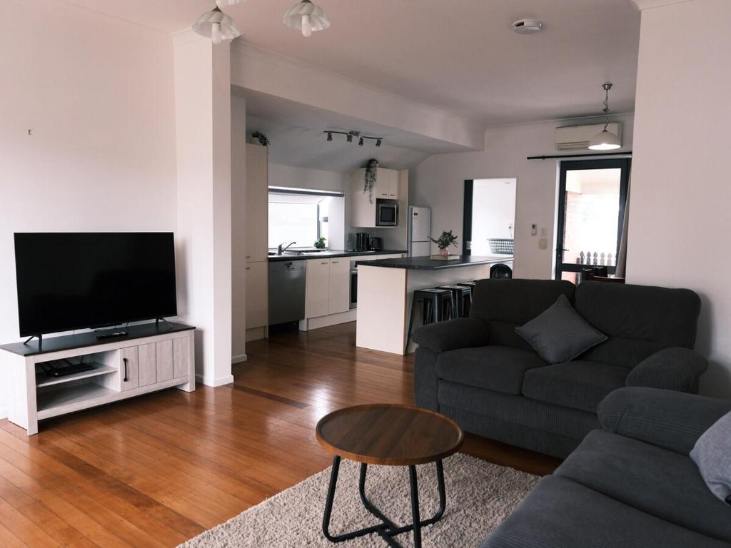 a living room with a couch and a television at Sweet Home in Avalon in Lower Hutt