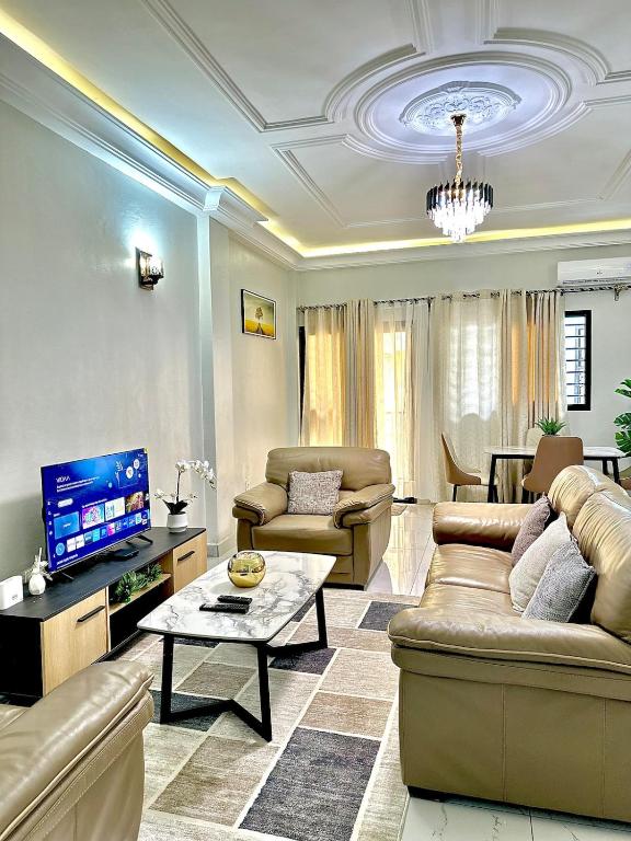 a living room with two couches and a tv at Aud'Meublé Logpom in Douala