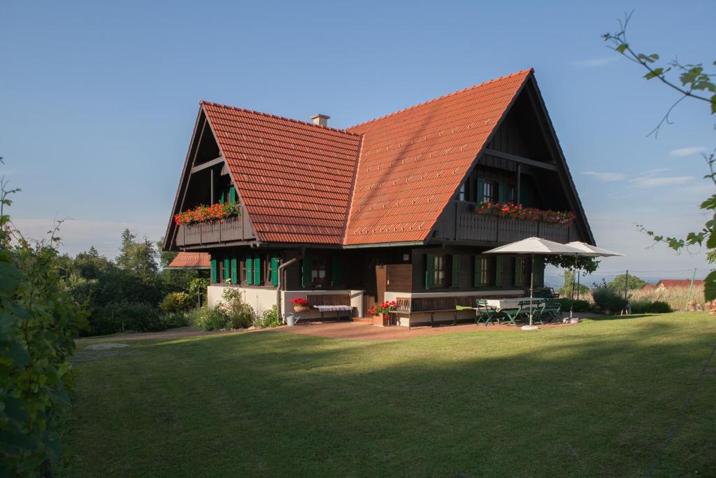 ein großes Haus mit orangefarbenem Dach auf einem Rasen in der Unterkunft Ferienhaus Neubauer in Spielfeld