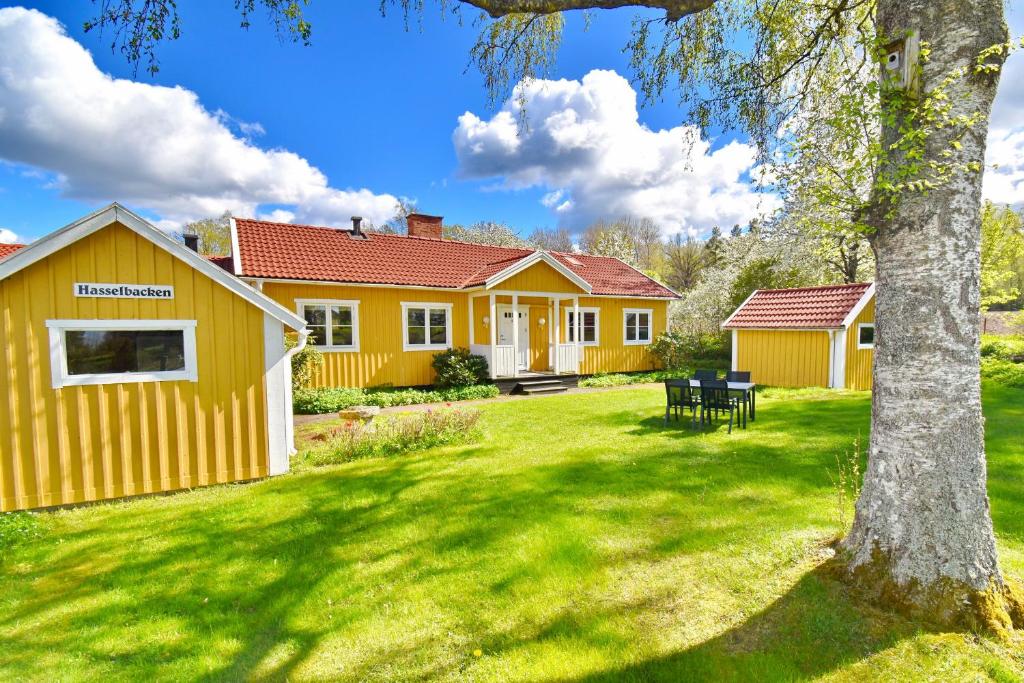 a yellow house with a tree in the yard at "Hasselbacken" in Vimmerby