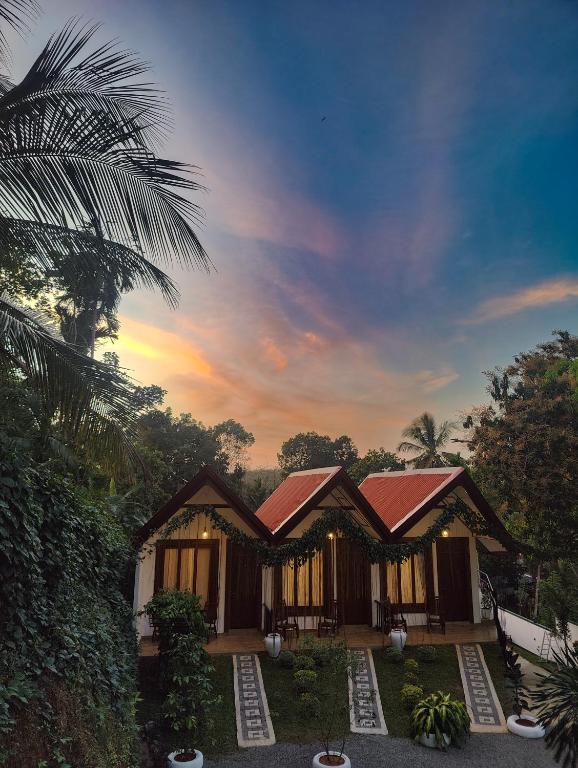 a house with a palm tree in front of it at Shalom Resort in Avissawella
