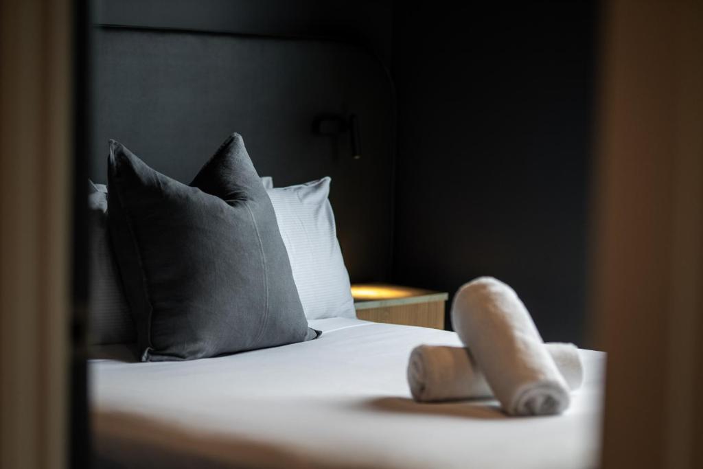 a bed with a pillow and two towels on it at Luna Lodge Wānaka - digital check-in only in Wanaka