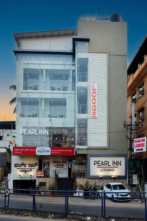 a car is parked in front of a building at Pearl Inn in Dhārwād