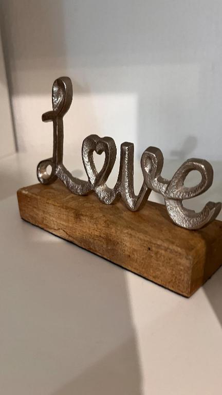 a metal sign that says love on a piece of wood at Cute apartment in lovely Constance in Konstanz