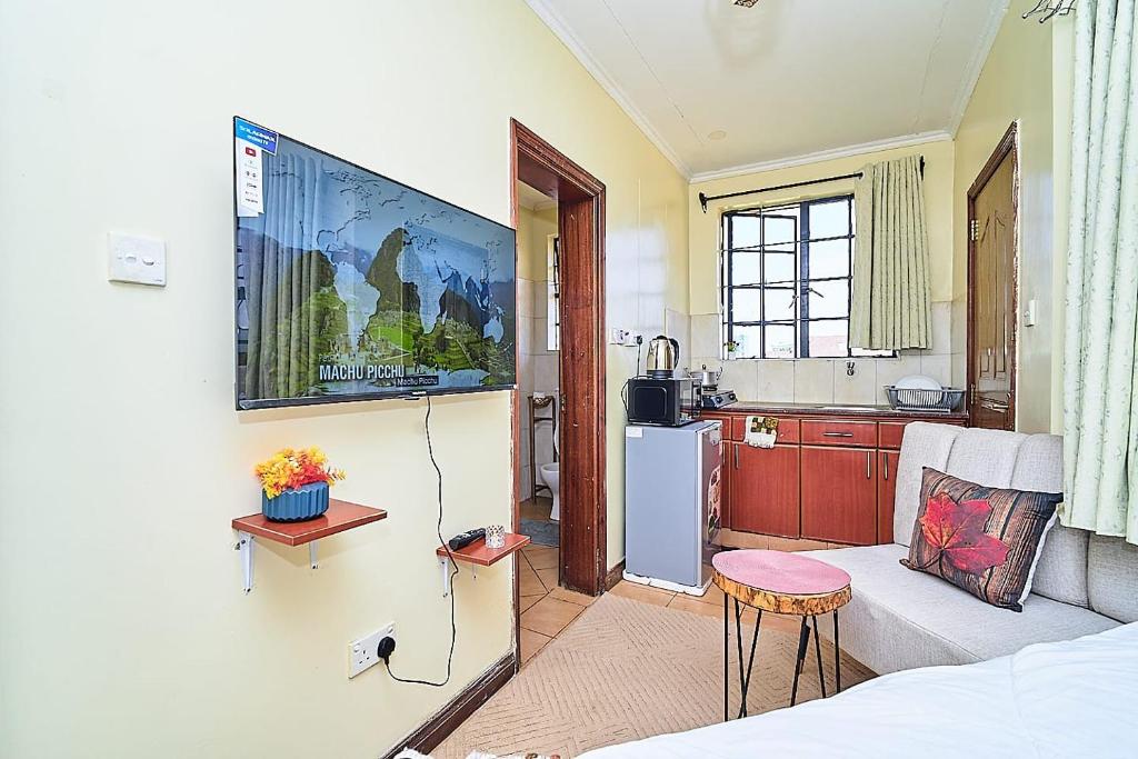 a living room with a couch and a kitchen at GoldKent Kileleshwa in Gatunga