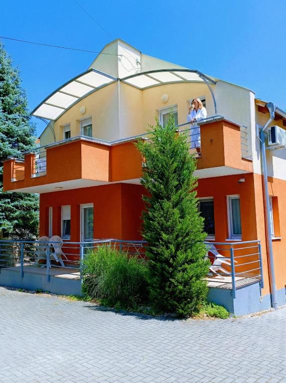 a man standing on the balcony of a house at Haus Maria Appartements in Zalakaros
