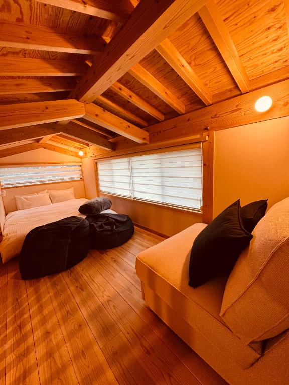 a bedroom with two beds and a wooden ceiling at CrossFit Otoyo Strength "TINY HOUSE" free Firepit, BBQ Grill, GYM in Otoyocho