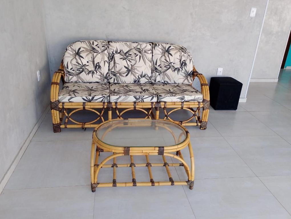 a wicker couch and a table in a room at Casa linda buzios in Búzios
