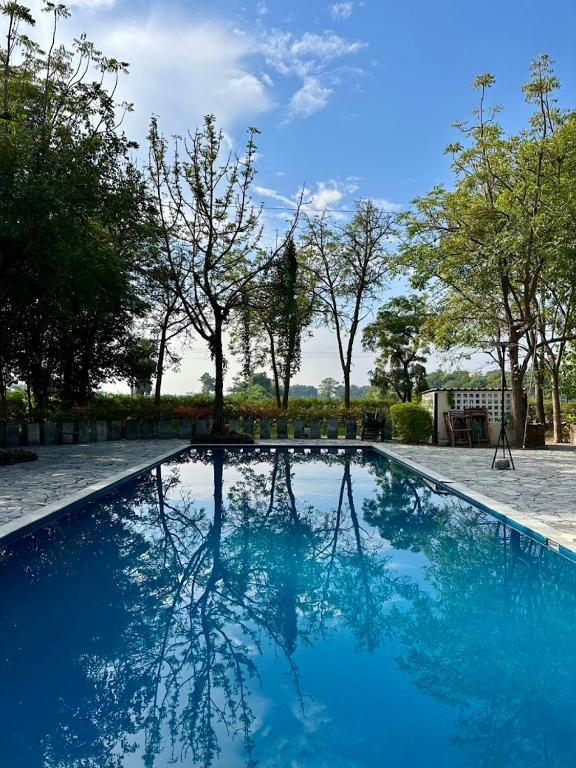 a blue swimming pool with trees in the background at สวนธรรมคยา in Ban Dan Chang
