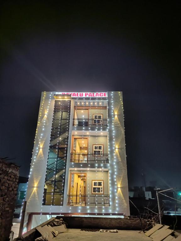 a tall building with lights on it at night at Hotel Dayalu palace in Vrindāvan