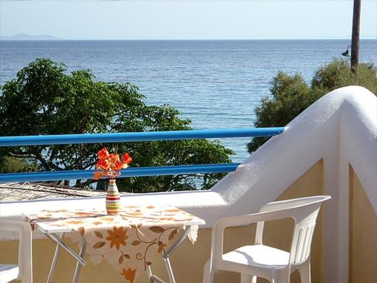 a table and chairs on a balcony overlooking the ocean at Oasis studios in Psili Ammos