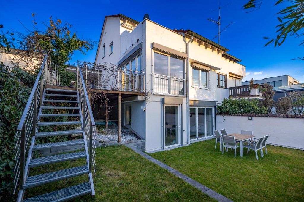 a house with a staircase and a table in the yard at Wellnessoase mit Sauna und Garten in Würzburg