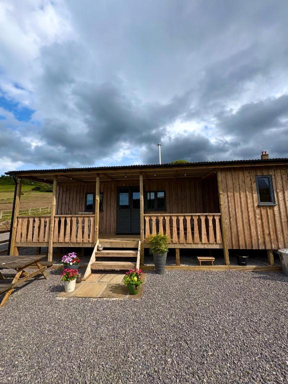 a building with a porch and flowers in front of it at Dark Skies den in Fryup