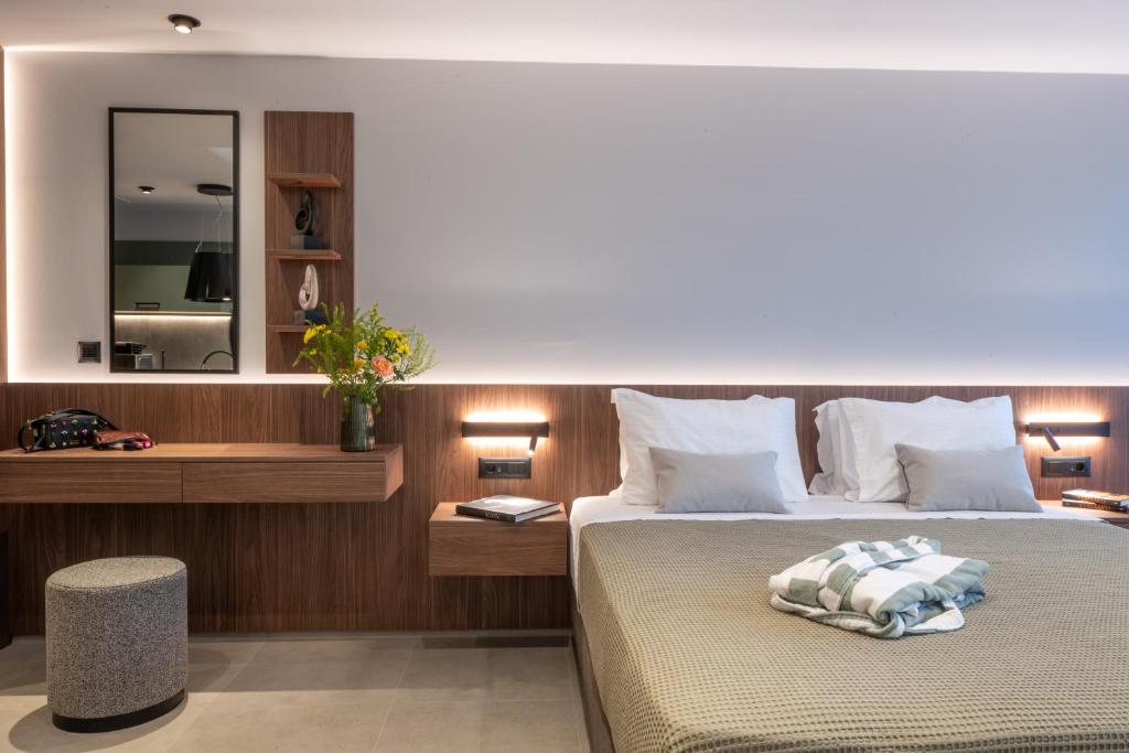 ein Hotelzimmer mit Bett und Spiegel in der Unterkunft CENTRO Suites in Kalamata