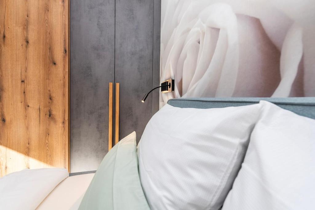 a bed with white sheets in a room at Aenna Apart Prutz in Prutz