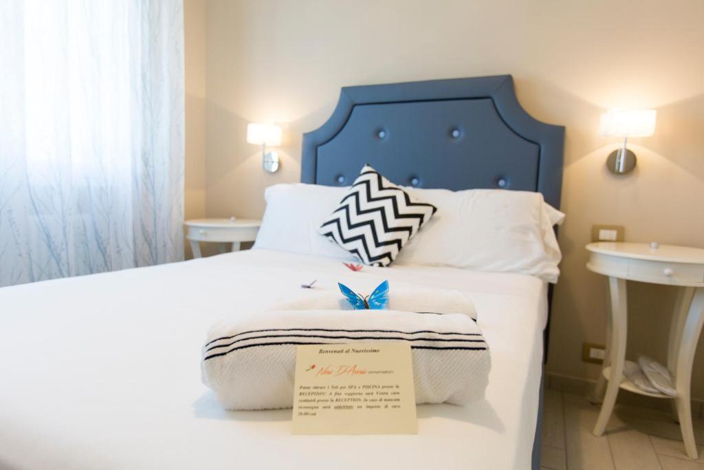 Una cama con un cabecero azul y una señal en ella en Nero D'Avorio Aparthotel & SPA en Rímini
