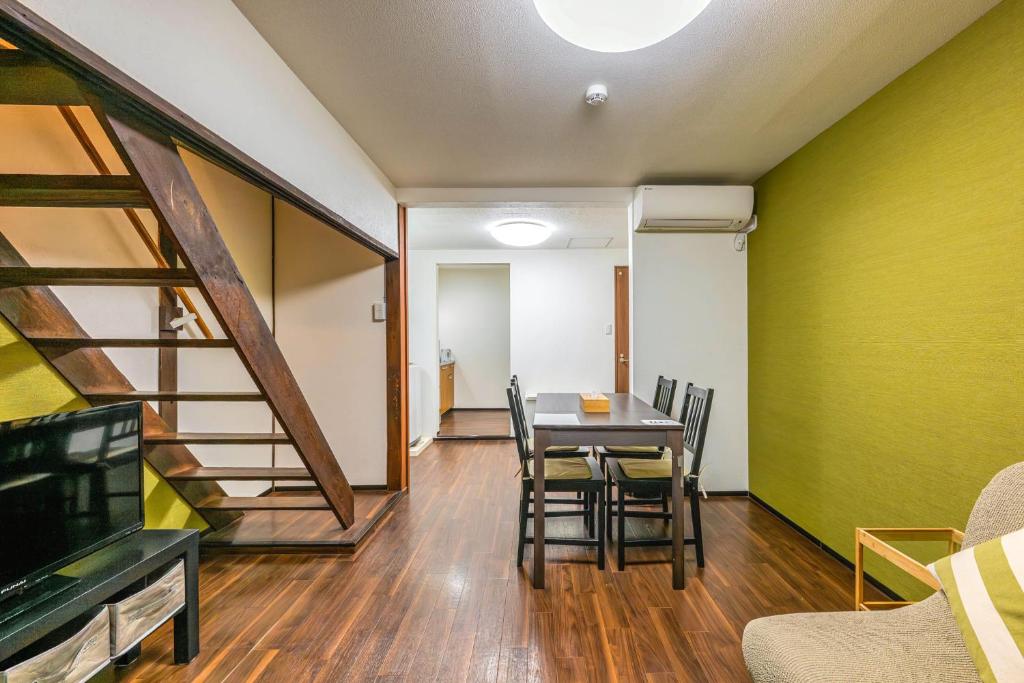 a dining room with a table and a tv at YAGARA TERRACE HOUSE OSAKA Room D in Osaka