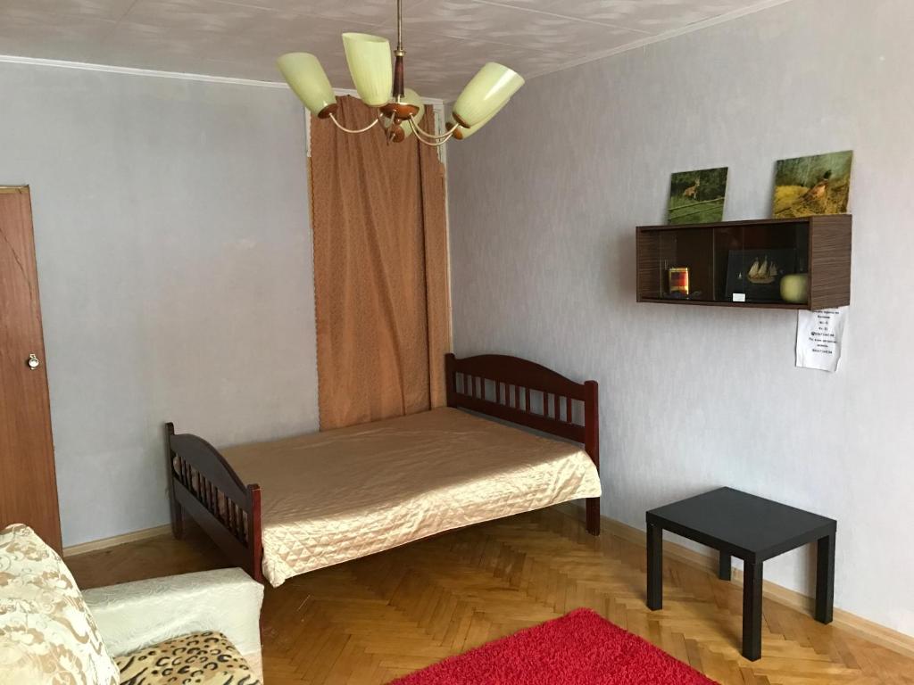 モスクワにあるG-Kvartal Oktyabrskoe Pole Apartmentのベッドとテーブル付きの小さな部屋