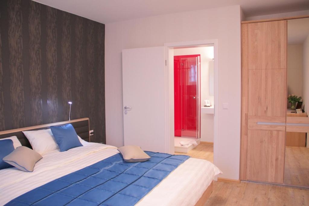 a bedroom with a large bed with blue and white pillows at BB Blick Hotel und Café in Bad Bellingen