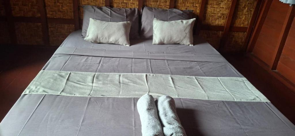 a bed with a pair of feet on it at Five Time homestay Syariah in Selaparang