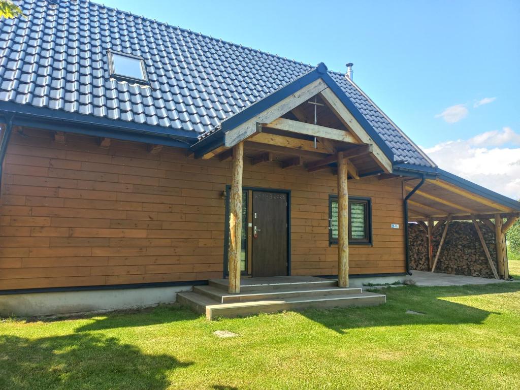 a wooden house with a porch and a door at Ancuty 20 in Ancuty