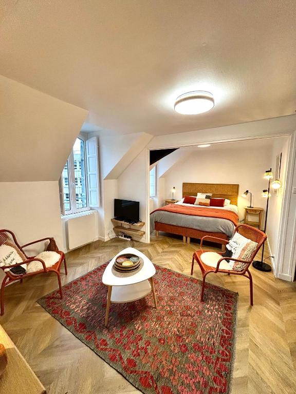 a bedroom with a bed and a table and chairs at Canopée - Appartement - Hyper centre ville in Quimper