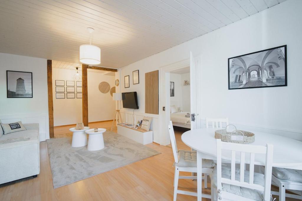 a living room with a white table and chairs at Hostellerie des Princes-Evêques - Le Mystère in Porrentruy