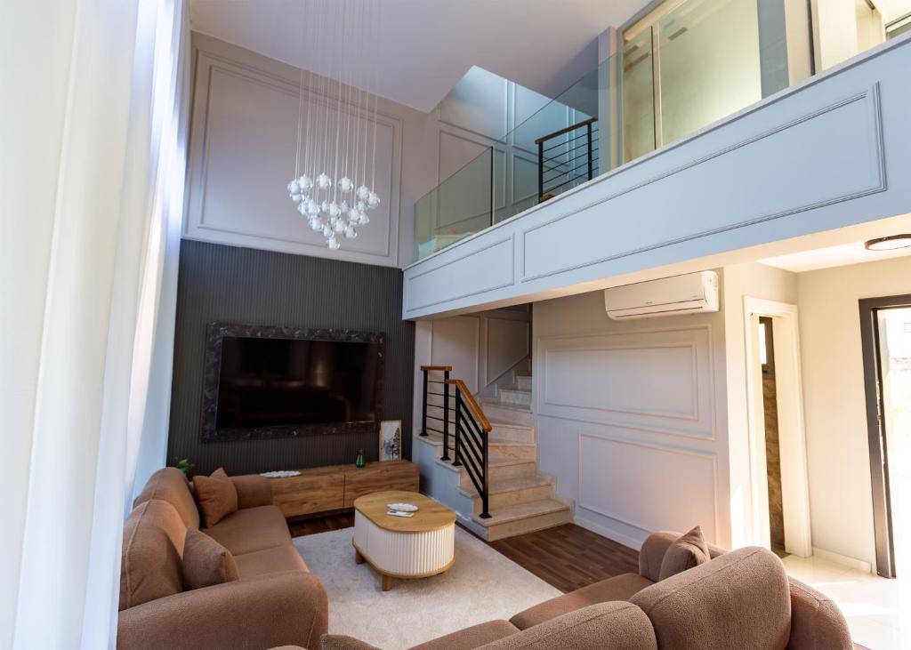 a living room with a couch and a tv at Delux SeaSide Victorious Villa by HolidayKeys in Kyrenia
